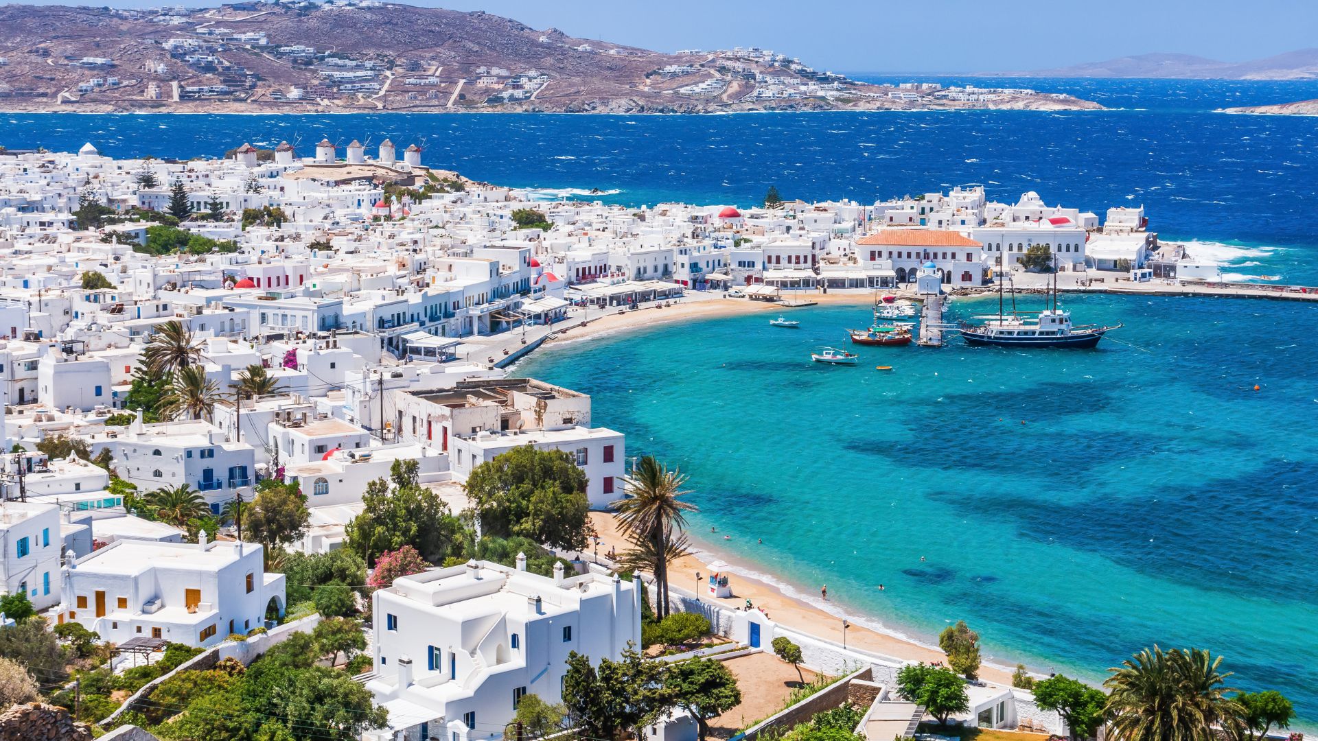 Panoramic view of Mykonos Town with iconic white buildings and windmills - Ten Reasons to Visit Mykonos